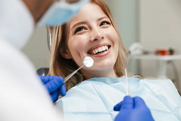 A female patient happily waiting in a dental chair for her dentist to begin her routine dental exam, at McHenry Smile Center.