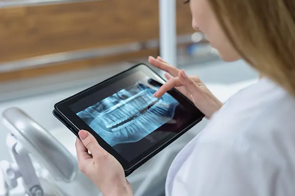 A dentist reviews a patient's digital x-rays on her tablet device, at McHenry Smile Center.